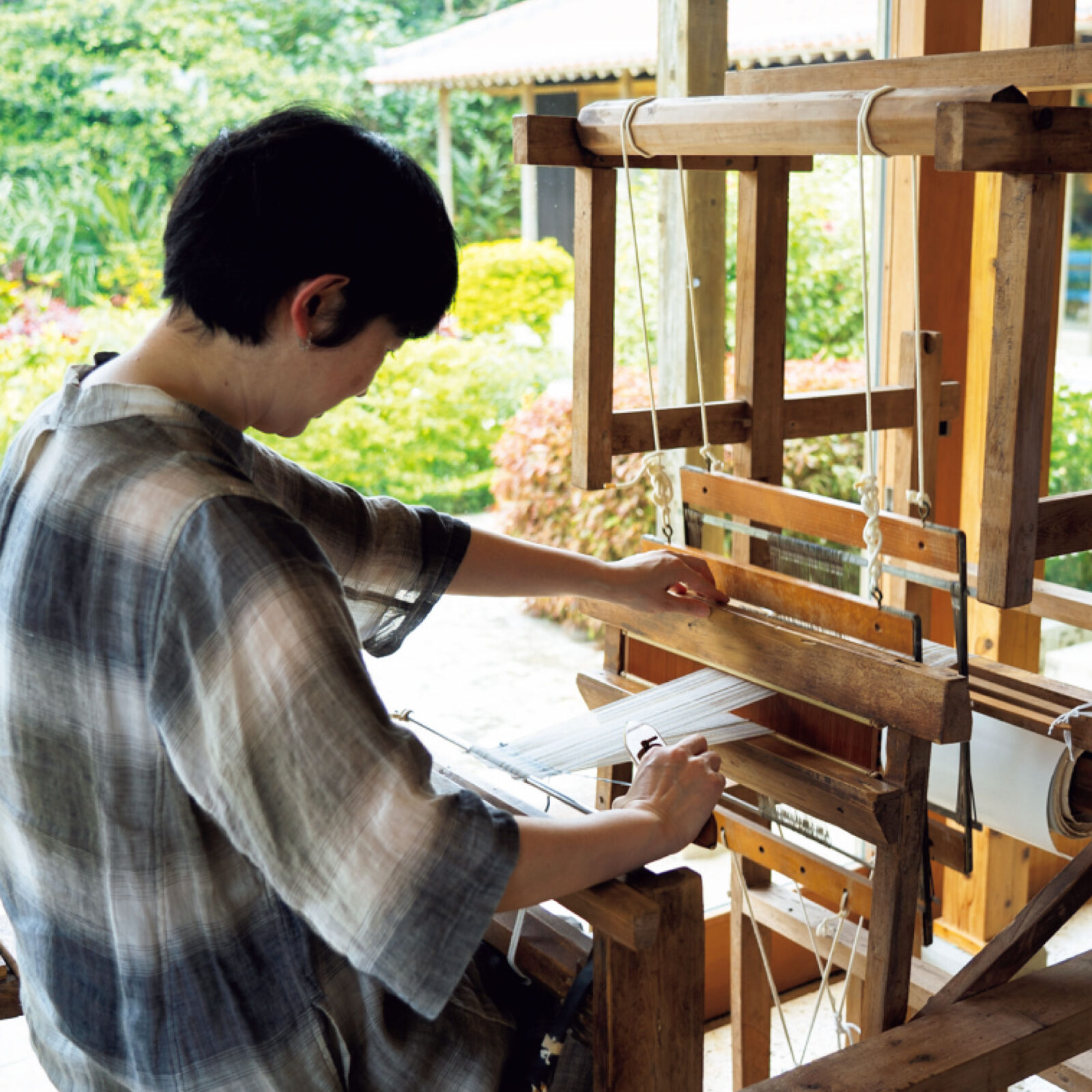 〈星のや〉のアクティビティ「織りあそび」は、足踏み式木製織り機で伝統的なミンサー織りを体験する様子