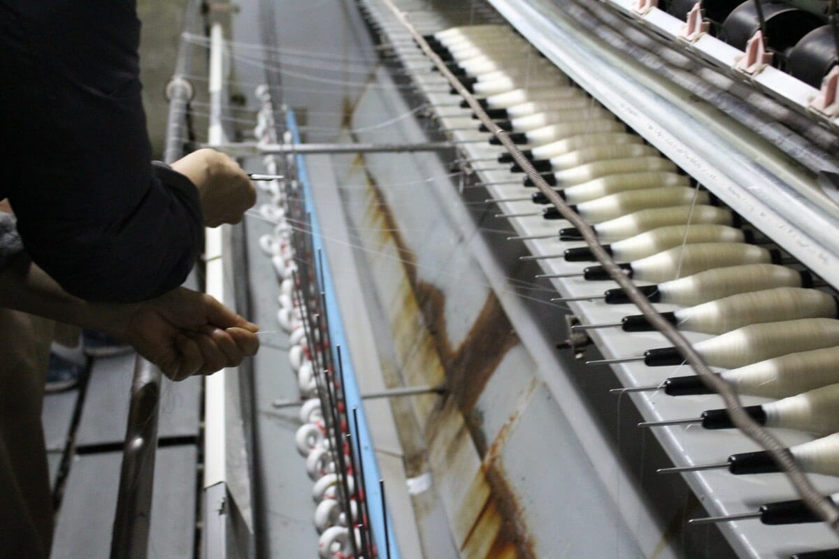 滋賀県の製織工場で機械で紡ぐ様子