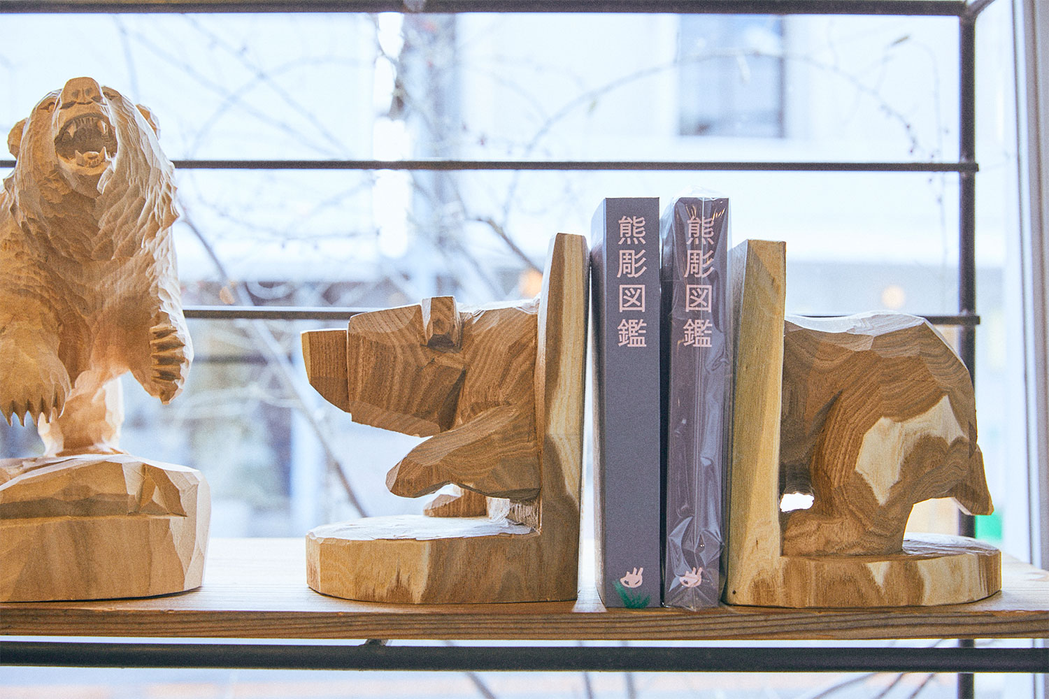 木彫りの熊を前足部分と後ろ足部分で前後に分けてブックエンドにした佐藤憲治氏の作品