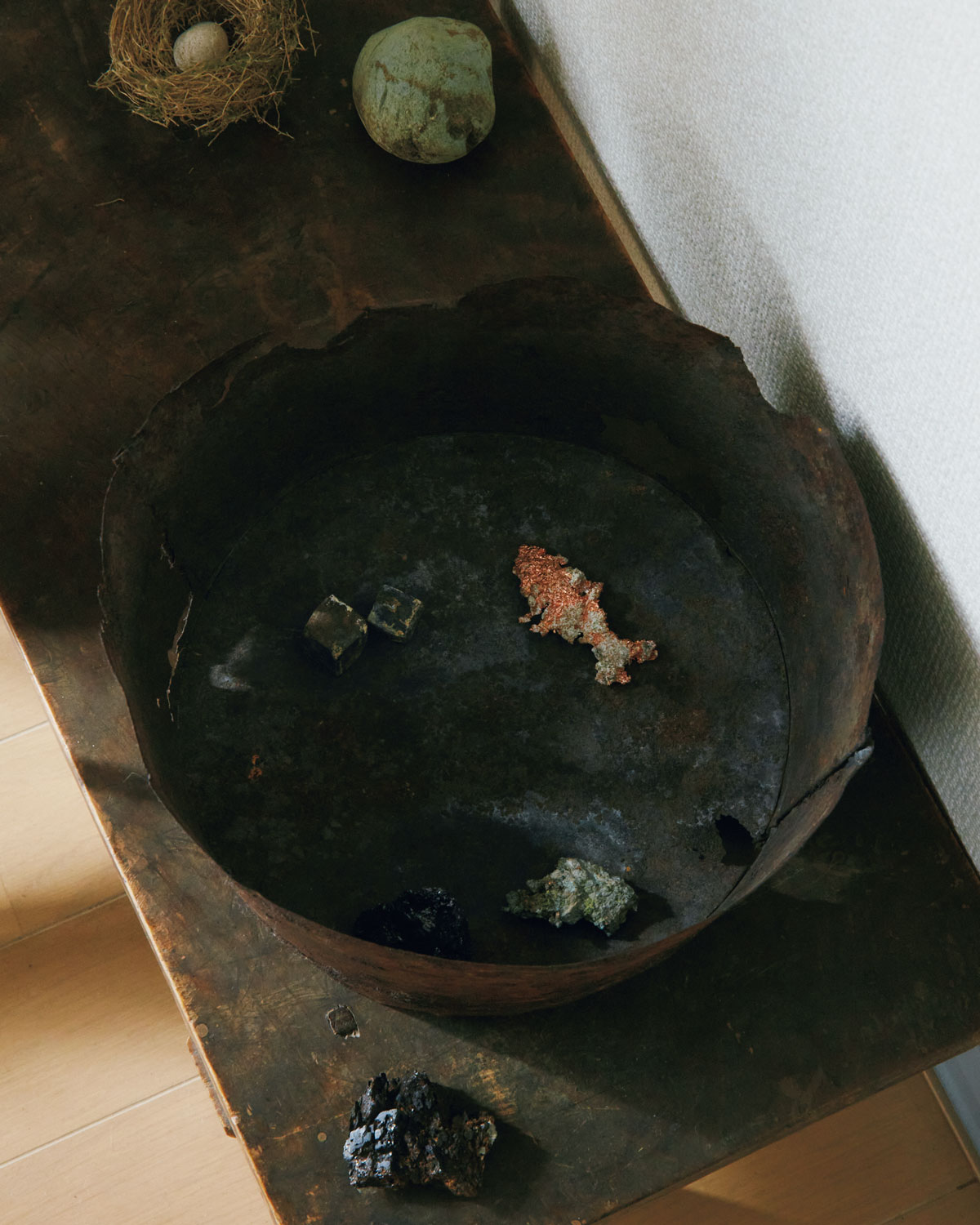 古道具の銅鉢の中に置かれた、魚の形をしたカッパーやキューブ形のゲーサイト